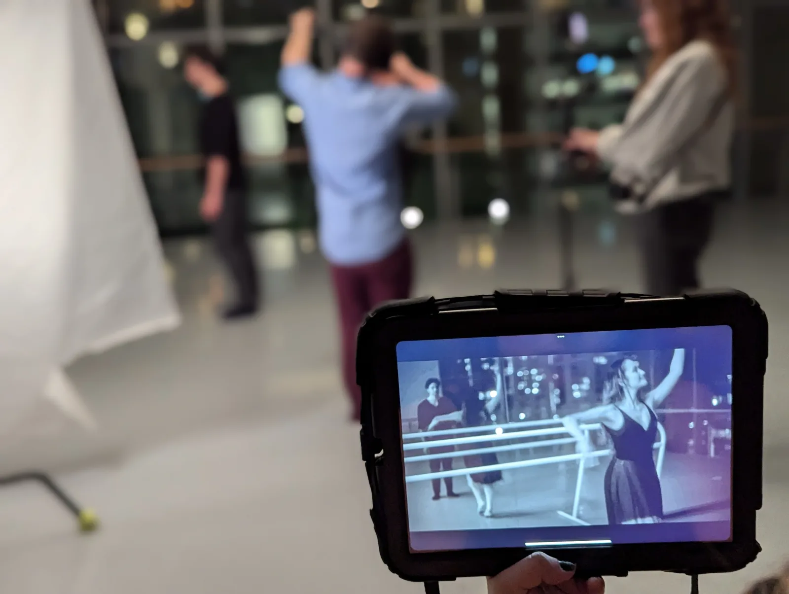 Behind the scenes: dancers seen through a director's monitor on a night shoot